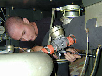 Airman 1st Class Grant Wiles changes a water filter on a portable air conditioner at Eglin Air Force Base, Fla. Hes part of a team that hit an in-commission rate of 100 percent on their aerospace ground equipment -- the first time thats happened for his unit in at least four years. 